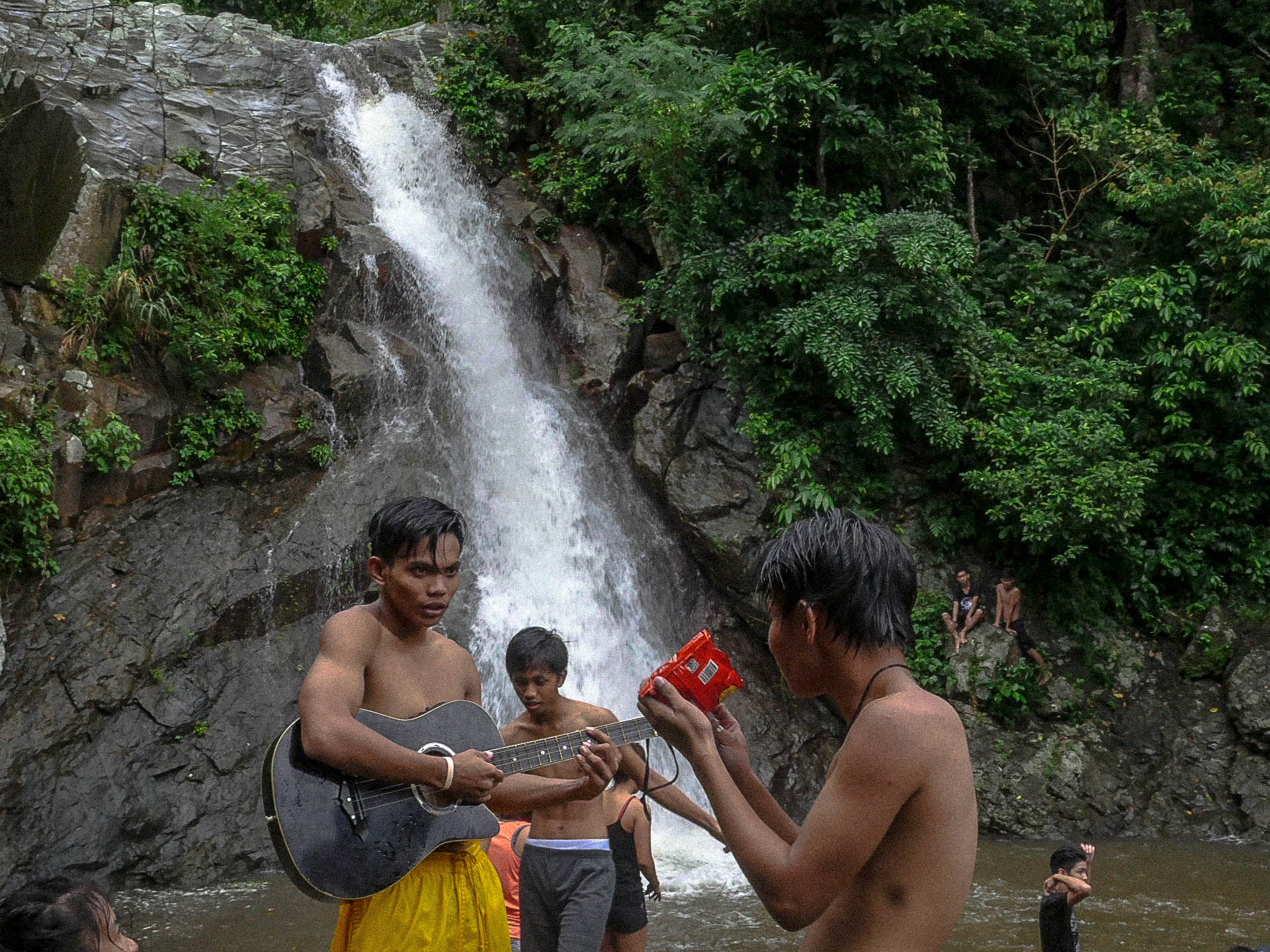 filipino youth with guitar at maribina falls in bato catanduanes philippines